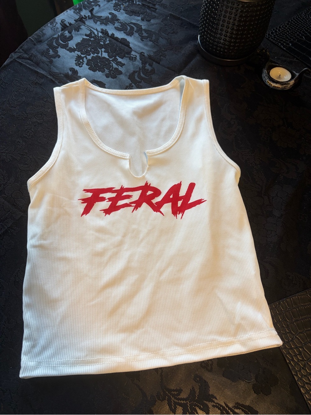 White Ribbed Cropped tank top with notched U-neck. Feral written in red on chest